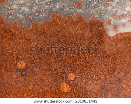 Rusted galvanized metal sheet texture with wavy corrosion border and rust spots on grey steel surface