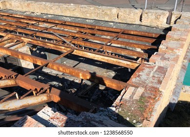 Rusted Girder Roof System. Modern Frame Work Of Metal Construction Carcass Roof Support Of Building. Rusty Metal Beam. Open Roof With Carcass Girders Of An Old Brick House
