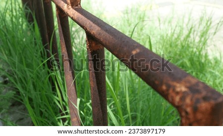 Rusted iron fence in the middle of a field