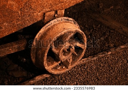 Rusted old minecart wheel on rail