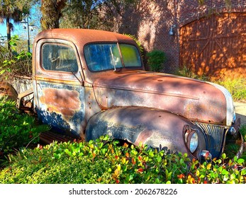 a rusted old vintage automobile car truck backyard junk garden monument display historic landscape background