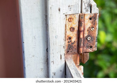 A rusted out butt hinge on the top half of a dutch door