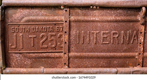 Rusted Tailgate And License Place On Old, Abandoned Pickup Truck.