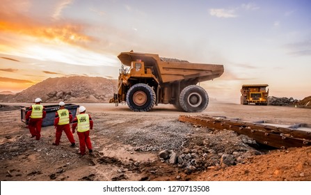 Rustenburg, South Africa, October 15, 2012, Large Dump Trucks transporting Platinum palladium ore for processing with mining safety inspectors in the foreground