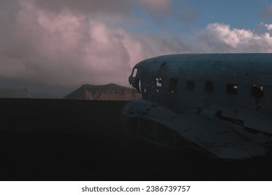 A rustic abandoned airplane in the foreground of the majestic mountain Petursey, Iceland