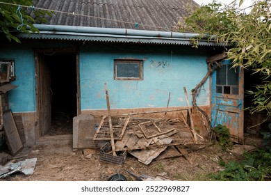 Rustic Abandonment: A Weathered Blue Cottage Surrounded by Nature. - Powered by Shutterstock