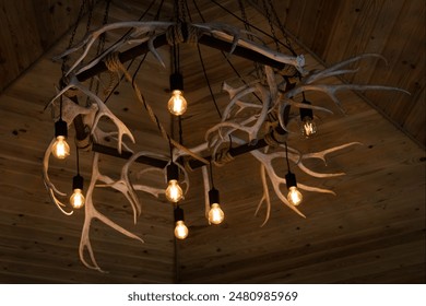 Rustic antler chandelier with gauss blur effect. Chandelier on wooden ceiling - Powered by Shutterstock