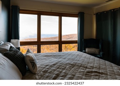 Rustic apartment home with bedroom window view from bed of Wintergreen, Virginia blue ridge mountain view in autumn fall season with orange foliage - Powered by Shutterstock