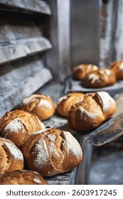 Rustic artisan bread cooling on stone surface after baking