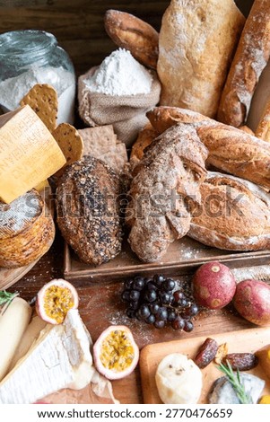 A rustic assortment of artisanal breads, cheeses, and fresh fruits displayed on a wooden table, evoking a cozy, farmhouse kitchen vibe.