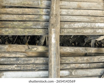 A rustic background texture of an old, weathered, and decaying floor or surface made from traditional bamboo slats.