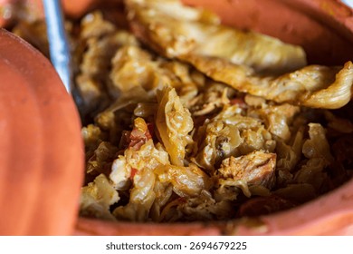 Rustic baked cabbage with meat served in traditional clay pot. Authentic homemade Serbian or Balkan winter food, comfort dish made with sauerkraut and pork