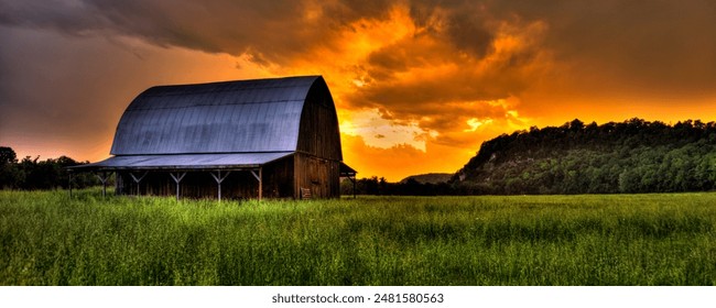 A rustic barn against a dramatic sunset sky