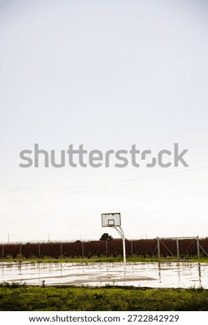 Rustic basketball hoop on empty outdoor court in rural field