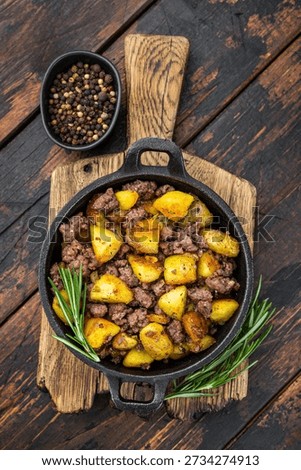 Rustic beef hash with fried potatoes served in a cast iron skillet on a wooden board perfect for comfort food and recipe visuals