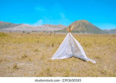 Rustic bohemian style tent on the savana, with mountain background. And the blue sky