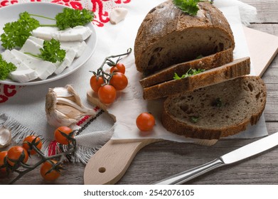 Rustic Bread with Feta, Parsley, and Cherry Tomatoes, Fresh Ingredients on Wooden Board. Feta-Topped Bread with Herbs and Tomatoes, Rustic Kitchen Setup. - Powered by Shutterstock