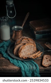 Rustic bread on earthenware plate with a cloth and vintage books; an old-world charm atmosphere.