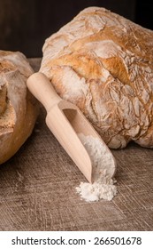 Rustic bread and wheat on an old vintage planked wood table.