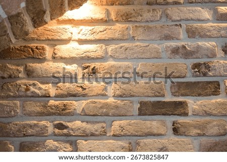 Rustic brick wall illuminated by warm indoor lighting