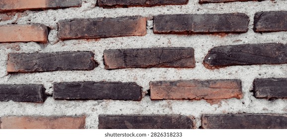A rustic brick wall with a weathered look and a thick mortar texture.