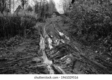 Rustic broken road in spring and house in the background.