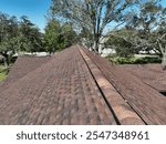 Rustic brown shingles on a residential home featuring the ridge vent.