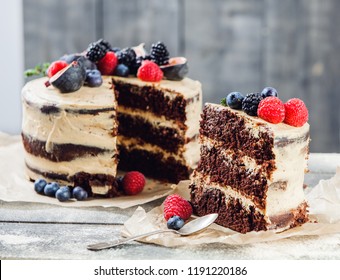 Rustic chocolate cake with buttercream frosting and decorated with berries and figs