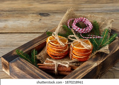 Rustic christmas composition with dried oranges, cinnamon sticks and fir tree branches in a wooden box.
