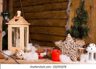 Rustic Christmas Still Life With Handcrafted Decorations Including A Wooden Lantern, Star Of Entwined Twigs, Candles And Kapok Snow In The Interior Of A Wooden Cabin Or Hut