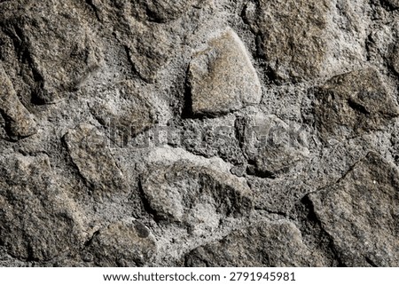 A rustic cobblestone wall bonded with rough cement mortar for heavy masonry construction.