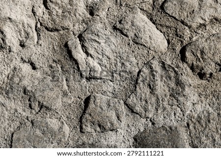 Rustic cobblestone wall bonded with rough cement mortar for heavy masonry construction.