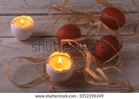 Rustic composition with candles and eggs. Happy easter. Selective focus.