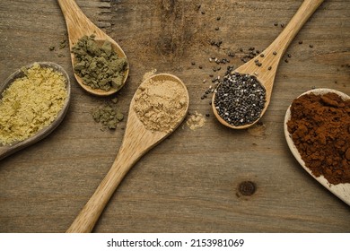 Rustic composition of superfoods on wooden spoons. Maca, Chia, Hemp Protein, pure Cocoa and nutritional yeast, all of them sources of vitamins and omega-3. Healthy lifestyle and diet concept. Top view