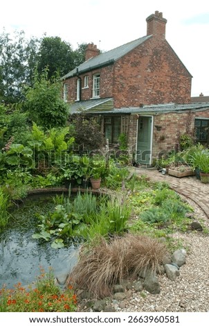 A rustic cottage surrounded by a vibrant garden featuring diverse plants and a peaceful pond, creating a tranquil outdoor space.
