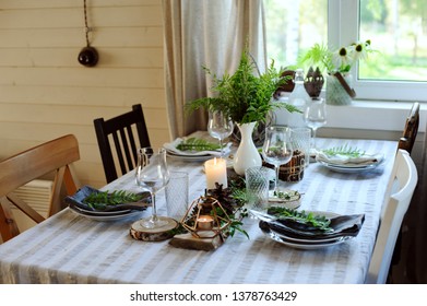 Rustic Country Kitchen Interior With Festive Table Setting For Summer Dinner In Natural Green And Brown Tones. Small Wooden Cottage.