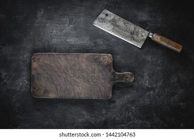 Rustic Cutting Board and Meat Cleaver on Dark Background. Butcher Shop Tool. - Powered by Shutterstock