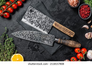 Rustic Cutting Board and Meat Cleaver on Dark wooden board. Black background. Top view. Copy space