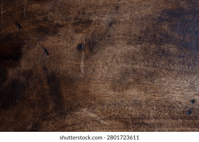 Rustic dark wood texture featuring worn scratches, knots and rich grain tones. Ideal as a background or tabletop surface for design projects, food styling, product photography and vintage layouts