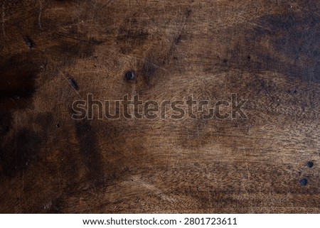 Rustic dark wood texture featuring worn scratches, knots and rich grain tones. Ideal as a background or tabletop surface for design projects, food styling, product photography and vintage layouts