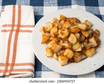 Rustic Diced Potato Hash On White Plate With Colorful Orange Plaid Napkin And Blue Plaid Tablecloth