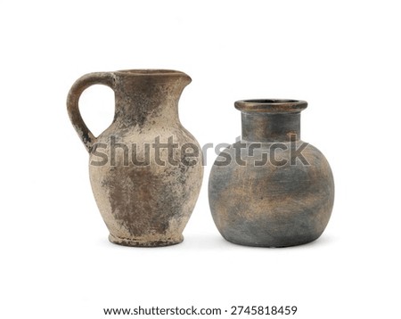 Rustic earthenware pitcher and dark textured vase on white background