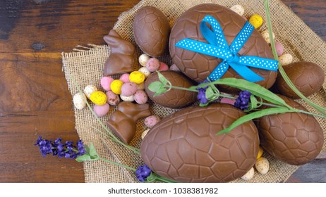 Rustic Easter Overhead With Chocolate Easter Eggs And Decorations On A Wood Table Background