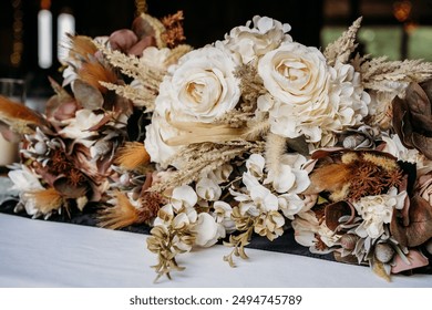 Rustic fall wedding bouquets with white roses laying on a wooden table.  - Powered by Shutterstock