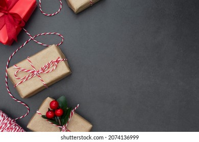 Rustic gift boxes over dark background. Christmas mock up with copy spacecfor text. Winter holidays with presents, top view, flat lay.