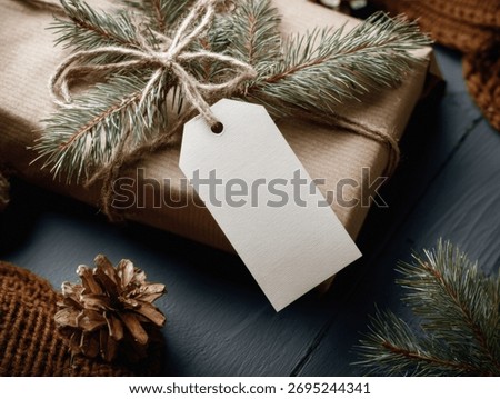 Rustic gift package with a blank tag and pine branches for a cozy holiday feel.
