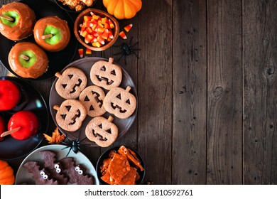 Rustic Halloween treat side border over a dark wood background with copy space. Top view. Variety of candied apples, cookies, candy and sweets. - Powered by Shutterstock