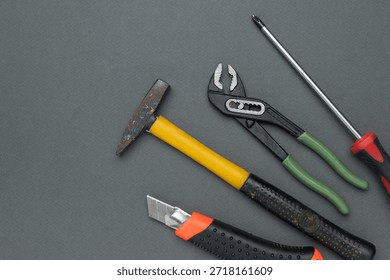 Rustic Hammer, Adjustable Pliers, Precision Screwdrivers, and Utility Knife on Gray Surface - Powered by Shutterstock - Get 15% off with code: PIKWIZARD15