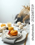 Rustic holiday table setup with plates, cutlery and autumn decorations