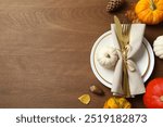 Rustic holiday table setup. Top view with plates, cutlery and autumn decorations. Empty space for your text 